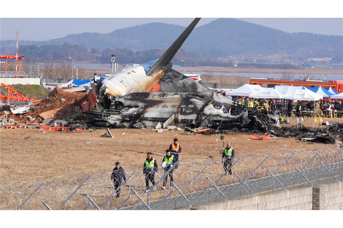 Feuerwehrleute und Rettungskräfte bergen die Opfer des verunglückten Flugzeugs auf dem internationalen Flughafen von Muan.