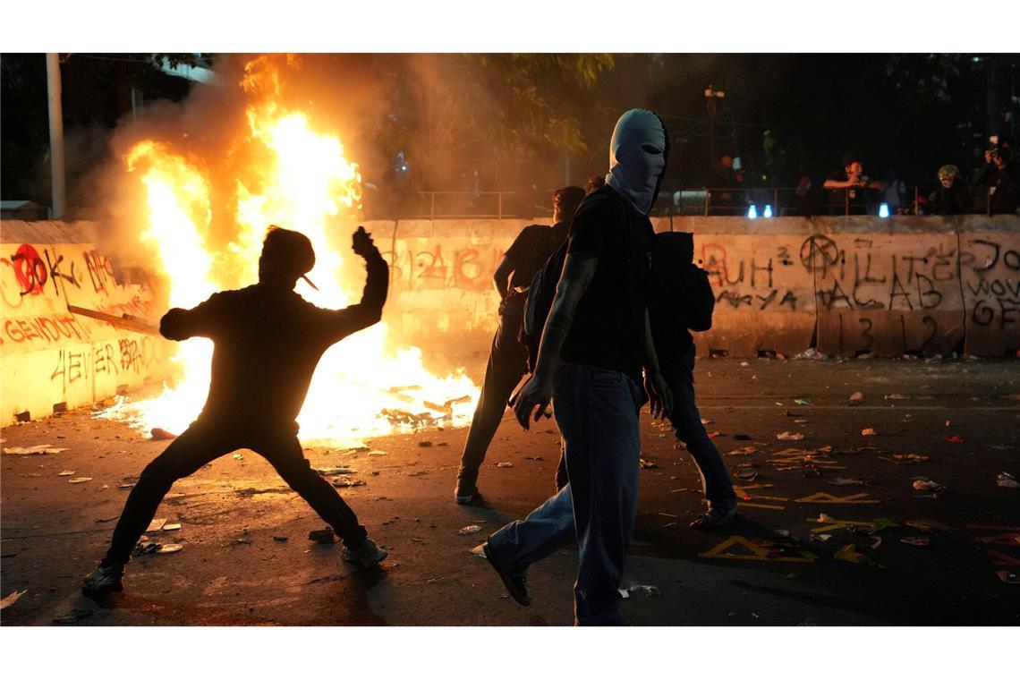 Flammender Protest: Demonstranten bewerfen die Polizei mit Steinen bei einer Kundgebung gegen die aktuelle Haushaltspolitik von Präsident Prabowo in Indonesien.