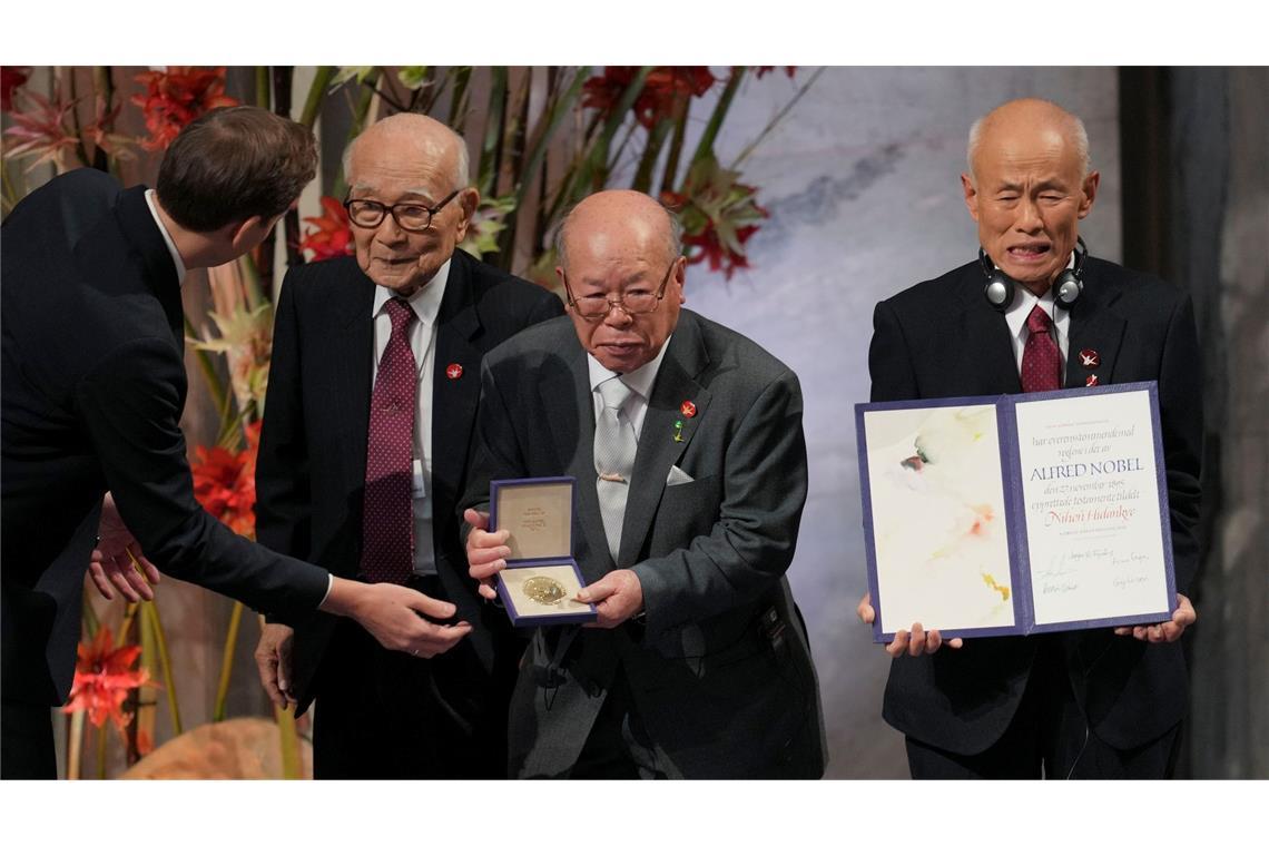 Friedensnobelpreis 2024: Der Vorsitzende des Nobelkomitees, Jørgen Watne Frydnes (l-r), steht mit Terumi Tanaka, Shigemitsu Tanaka und Toshiyuki Mimaki, den Vertretern des diesjährigen Friedensnobelpreisträgers Nihon Hidankyo (Japan Confederation of A- and H-Bomb Sufferers Organizations), bei der Verleihung des Friedensnobelpreises im Rathaus von Oslo.