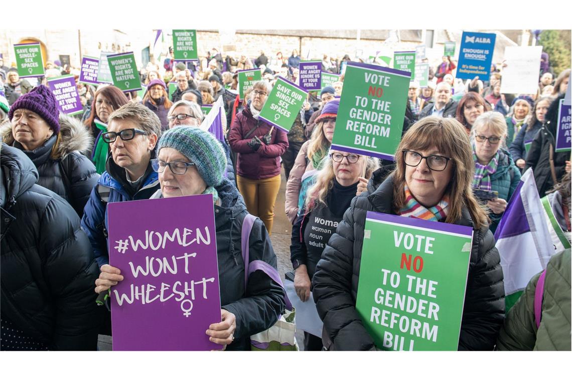 Gegnerinnen des Gesetzes zur Reform der Geschlechteranerkennung protestieren mit Plakaten vor dem Parlament in Edinburgh.