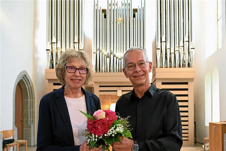 Gottfried Mayer hielt für sein Publikum ein spannendes Programm bereit – und für Silvia Jauß als 5000. Besucherin des Internationalen Orgelzyklus eine kleine Aufmerksamkeit. Die Auenwalderin, die oft und gern zu den Konzerten pilgert, bekam vom Murrhardter Kantor einen Blumenstrauß als Dankeschön. Foto: Elisabeth Klaper