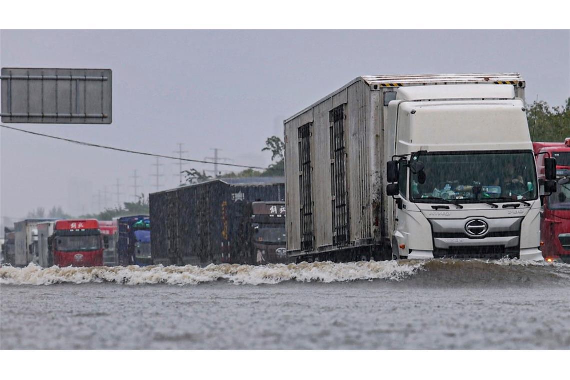 Große Lastwagen fahren durch ein Hochwasser in Shenyang in der nordostchinesischen Provinz Liaoning.