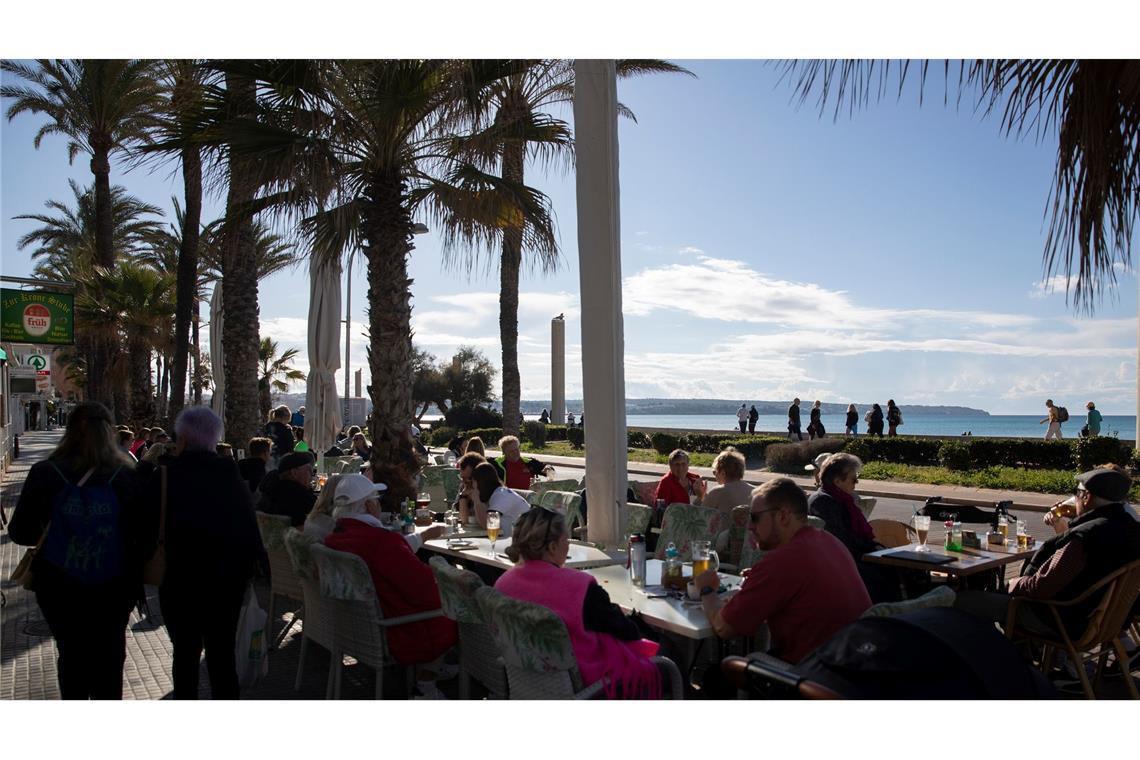 Gut besucht ist bei sonnigem Wetter eine Bar am Strand von Arenal auf Mallorca.