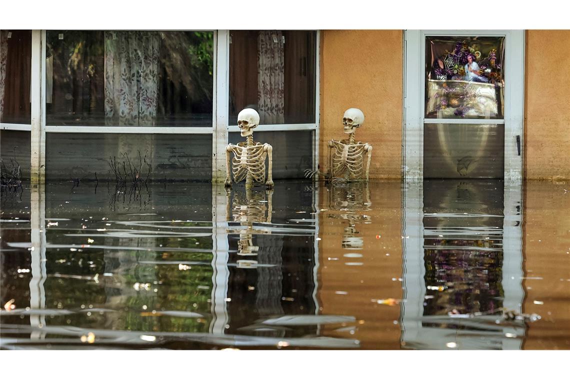 Halloween im Hochwasser: Zwei Deko-Skelette stehen bei Überschwemmungen nach Hurrikan Milton im US-Bundesstaat Florida bis über die knochigen Hüften im Wasser.