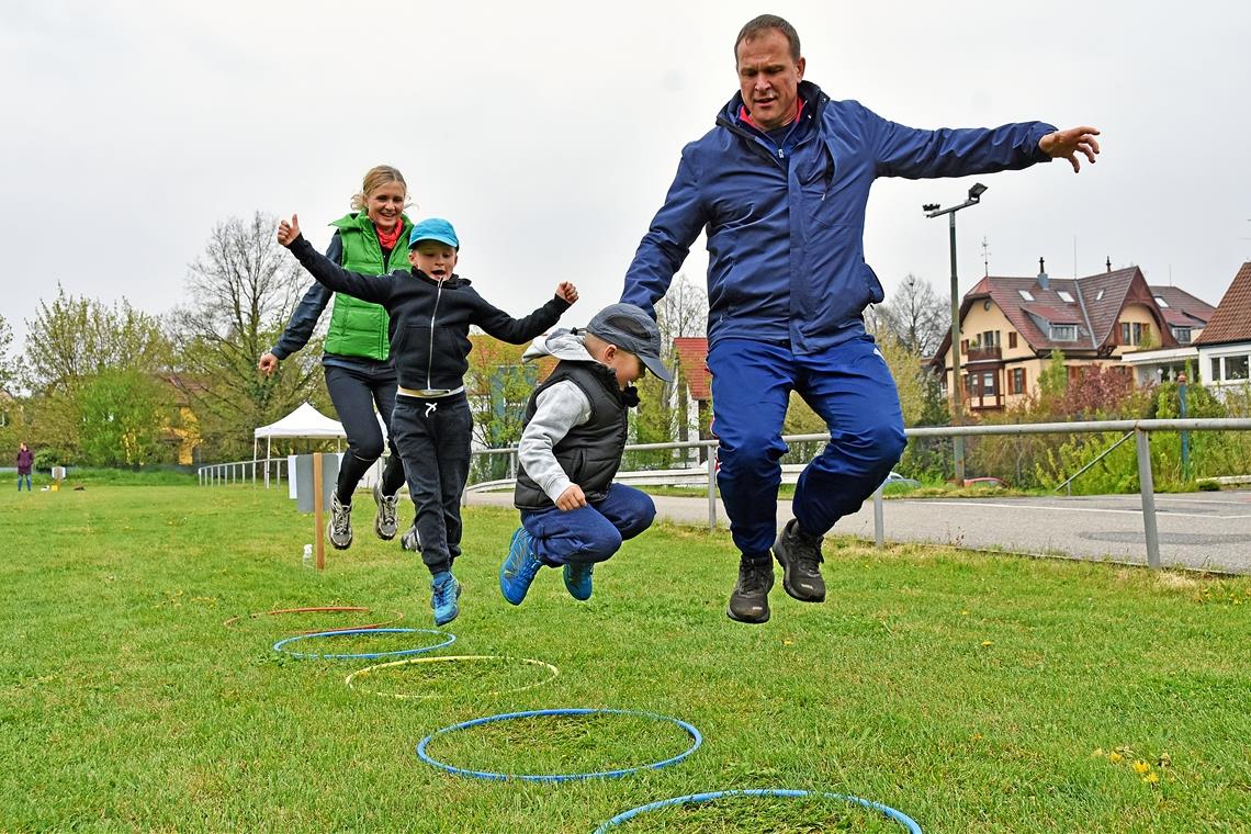 Hüpften vor Freude über den Bewegungsparcours auf dem Hagenbach: Andrea, Alexander, Fabian und Michael Flegler (von links). Das Angebot der TSG Backnang 1846 kommt bei Groß und Klein bestens an. In trüben Zeiten bietet der Sport den Familien ein wenig Abwechslung. Foto: T. Sellmaier