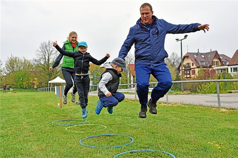 Hüpften vor Freude über den Bewegungsparcours auf dem Hagenbach: Andrea, Alexander, Fabian und Michael Flegler (von links). Das Angebot der TSG Backnang 1846 kommt bei Groß und Klein bestens an. In trüben Zeiten bietet der Sport den Familien ein wenig Abwechslung. Foto: T. Sellmaier