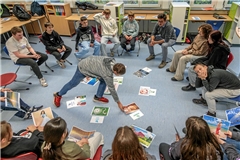 Im Kurs „Glück und Lebenszufriedenheit“ mit Konrektor Kai Kasper (hinten rechts) schauen sich die Schülerinnen und Schüler ihre Lebensziele an. Sie haben sich aus einem größeren Fundus für sie passende Bilder ausgesucht und sprechen darüber, was sie erreichen möchten. 