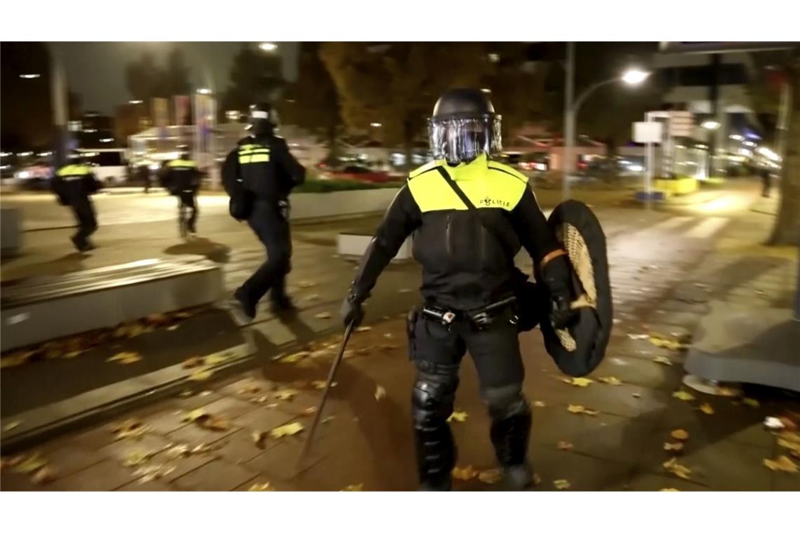 In diesem Videostandbild patrouillieren Polizisten in Einsatzkleidung durch die Straßen von Amsterdam.