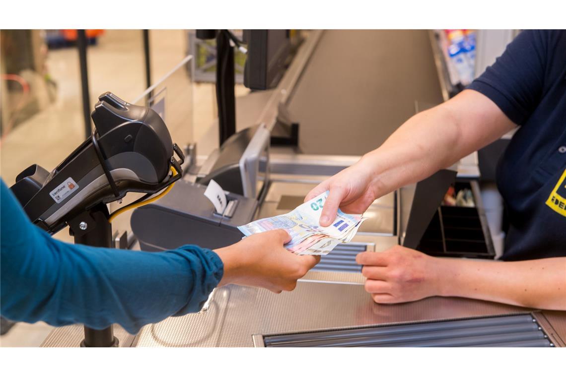 In einem Supermarkt hebt eine Kundin beim Bezahlen auch gleich Bargeld ab.