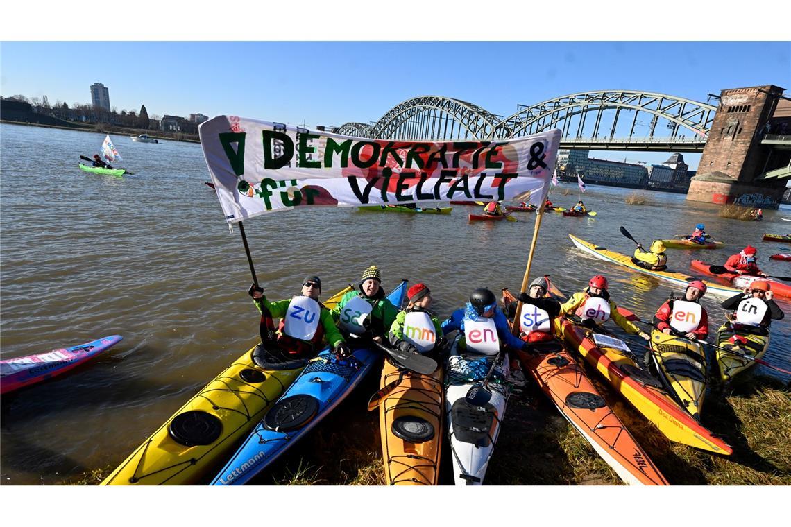 In Köln demonstrieren Wassersportler auf dem Rhein.