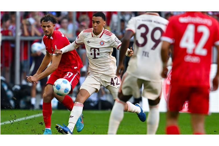 Jamal Musiala (2. von links) von München und Max Rosenfelder (links) von Freiburg kämpfen um den Ball.