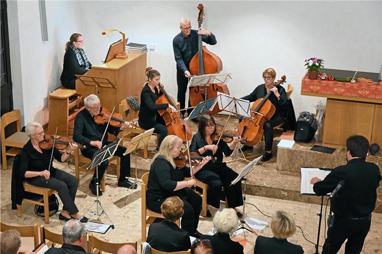 Julia Kirschbaum an der Orgel und die Streichergruppe werden von Uwe Matti (rechts) genauso wie die Chöre durchs Konzert geführt. Foto: Elisabeth Klaper