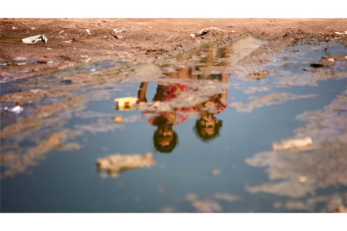 Kinder sitzen auf einer mit Abwasser überfluteten Straße in Deir el-Balah. Im Gazastreifen infizierte sich erstmals seit mehr als zwei Jahrzehnten wieder ein Kind mit dem Poliovirus (Archivfoto).