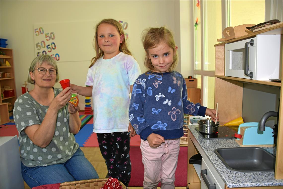 Kindergartenleiterin Sabine Macheleidt (von link) assistiert Nele und Haylie am Herd der kleinen Küchenzeile. Foto: Elisabeth Klaper