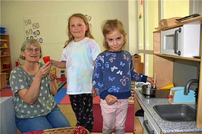 Kindergartenleiterin Sabine Macheleidt (von link) assistiert Nele und Haylie am Herd der kleinen Küchenzeile. Foto: Elisabeth Klaper