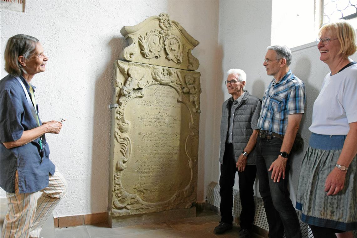 Kirchenführerin Angelika Szöke (von links) geht auf die Geschichten ein, welche die Grabinschriften in der Walterichskirche erzählen. Mit Rainer Hirzel, Oliver Burk und Elisabeth Zenker macht sie am Denkmal für Eberhardina Johanna Kölle halt, die noch vor der Geburt ihres Kindes starb. Foto: Elisabeth Klaper