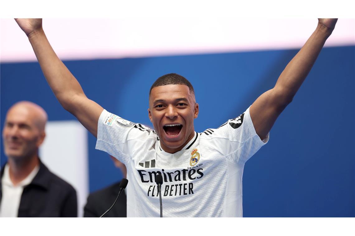 Kylian Mbappe reißt bei seiner Voirstellung bei Real Madrid die Arme in die Höhe.