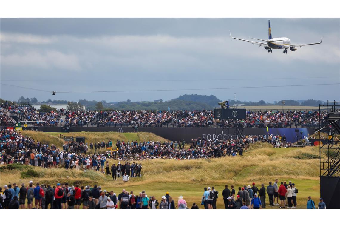 Landeanflug über Golfplatz:  Ein Flugzeug stetzt über den British Open Golffans zur Landung auf dem Flughafen Glasgow Prestwick an.