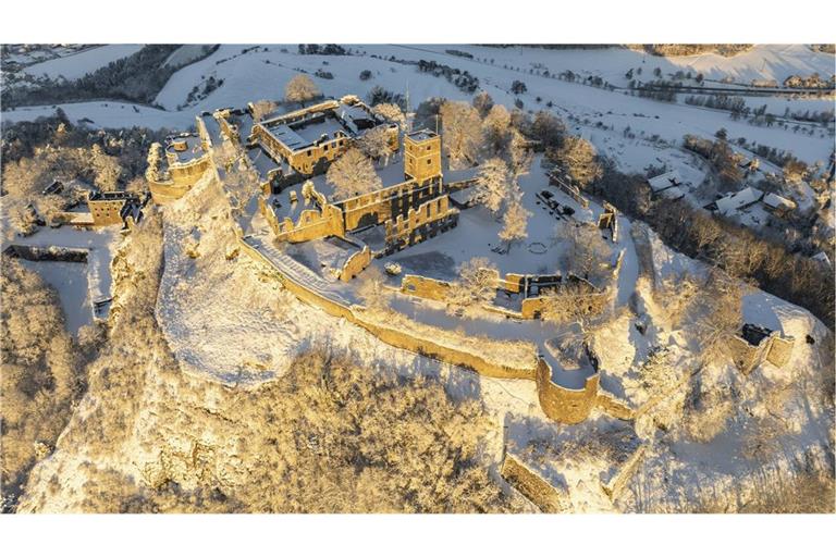 Luftbild vom verschneiten Hegauvulkan Hohentwiel mit Deutschlands größter Burgruine, der Festung Hohentwiel im Landkreis Konstanz, an einem kalten Wintermorgen am 24. November 2024  bei Sonnenaufgang.