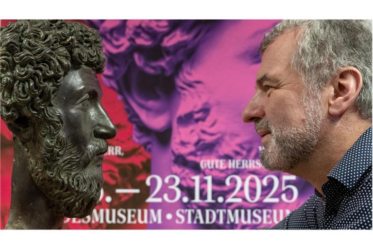 Marcus Reuter, Direktor des Rheinischen Landesmuseums in Trier, schaut sich vor einem Plakat zur Landesausstellung neben einer Nachahmung des Kopfes des römischen Kaisers Marc Aurel in die Kamera. Die Ausstellung im Rheinischen Landesmuseum und dem Stadtmuseum Trier ist vom 15. Juni bis 23. November 2025.