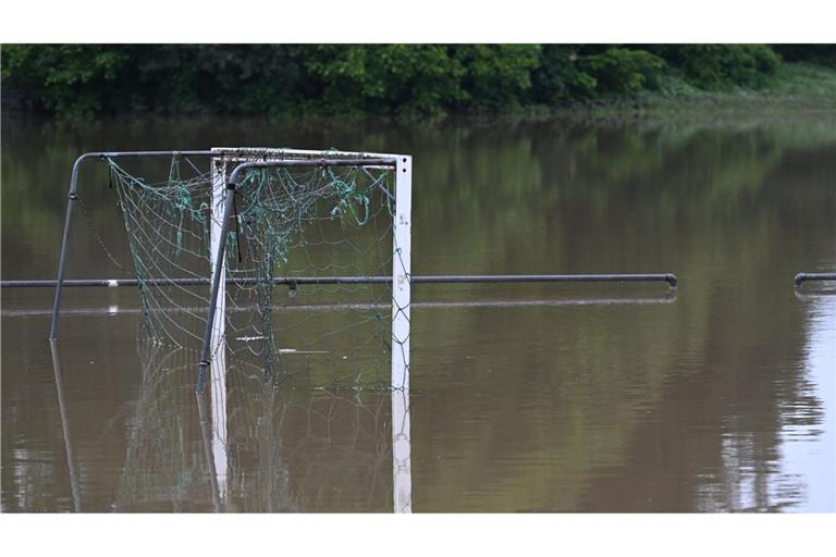 Meckenbeuren-Brochenzell: Ein Fußballtor spiegelt sich im  Wasser auf einem überschwemmten Sportplatz.