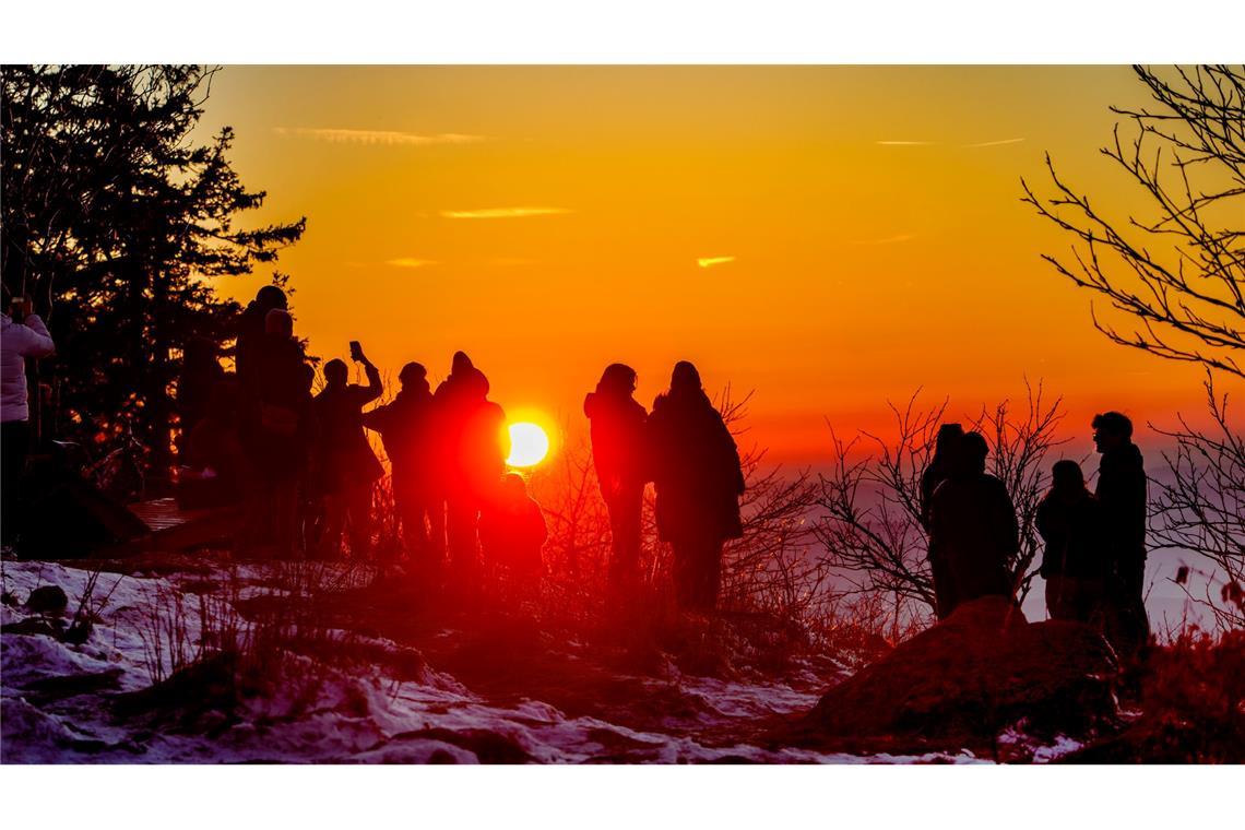 Menschen betrachten den Sonnenuntergang vom Feldberg-Plateau aus.