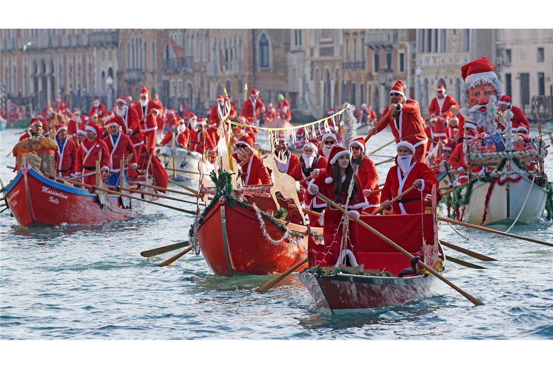 Menschen in Weihnachtsmann-Kostümen fahren in Gondeln auf dem Canal Grande in Venedig.