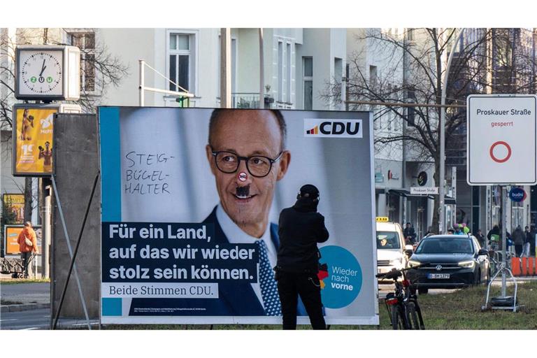 Mit Schmierereien verunziertes Wahlplakat von Friedrich Merz.