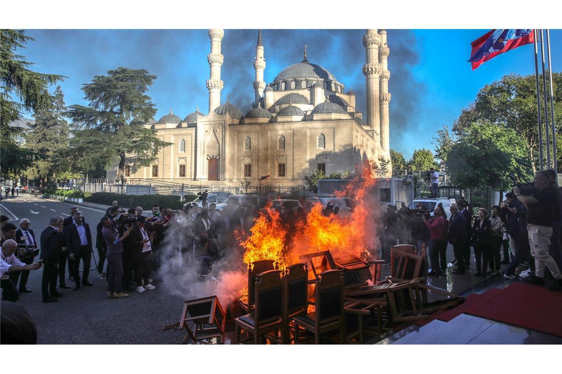 Mitglieder der oppositionellen Demokratischen Partei Albaniens verbrennen Stühle am Eingang des Parlaments mit den Worten, dass ihre Stühle den Bürgern gehören.