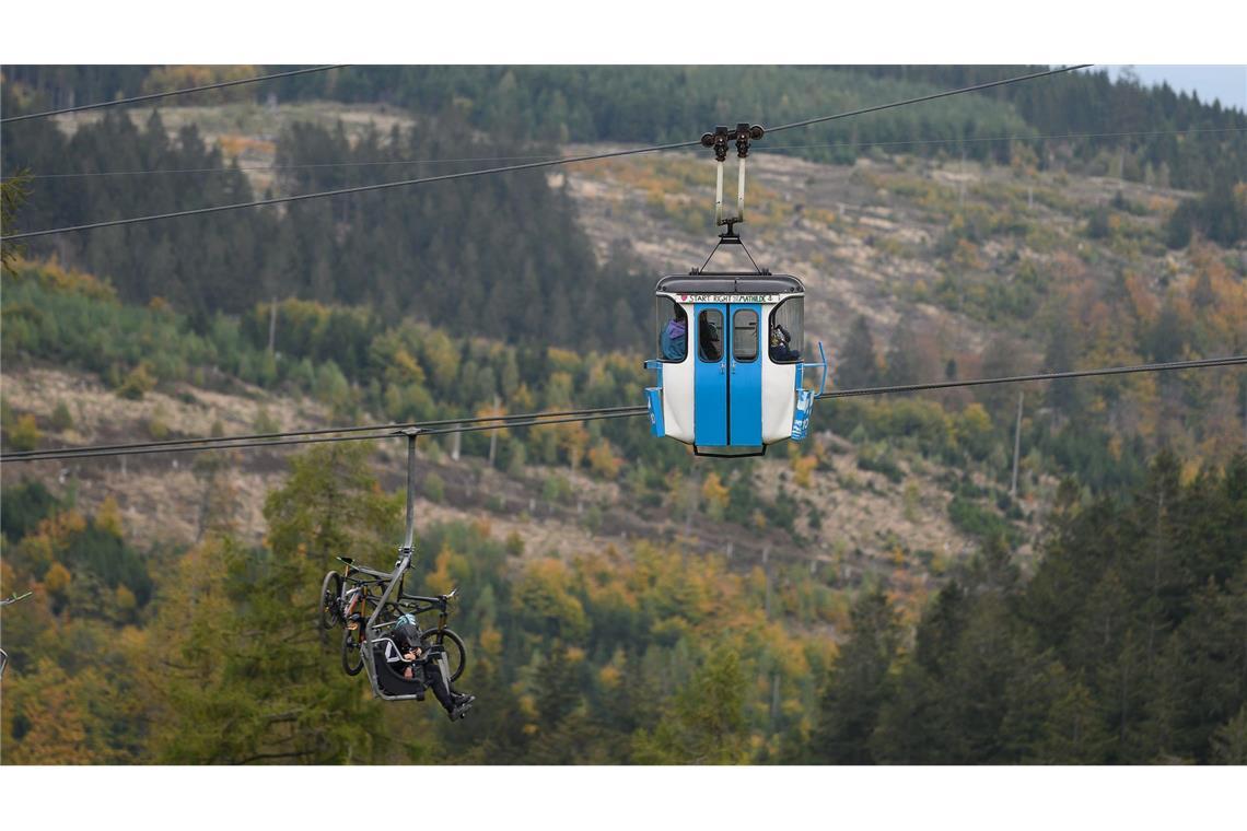 Mountainbiker und Wanderer schweben gemeinsam in Gondel und Sessellift über den Bocksberg im Harz