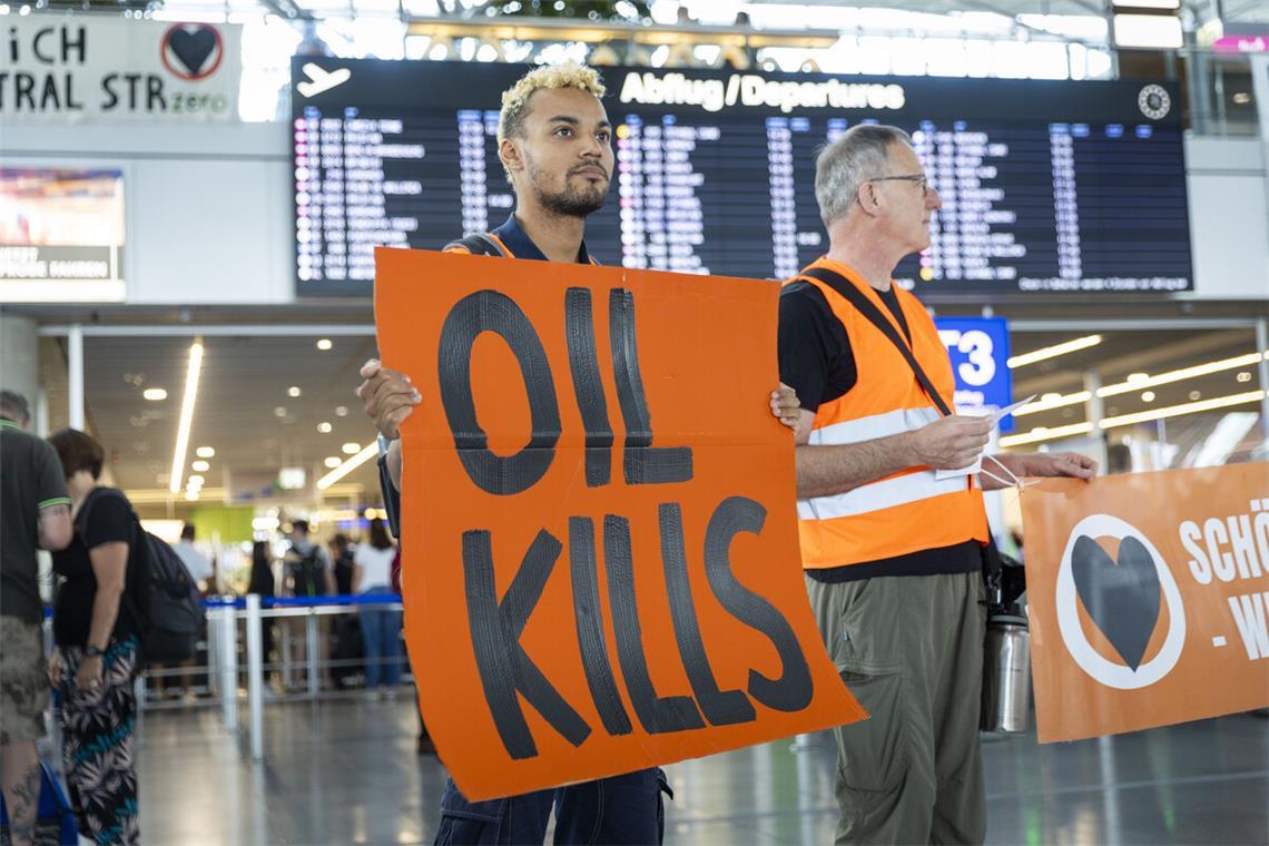 „Öl tötet“ steht auf dem Plakat eines Aktivisten.