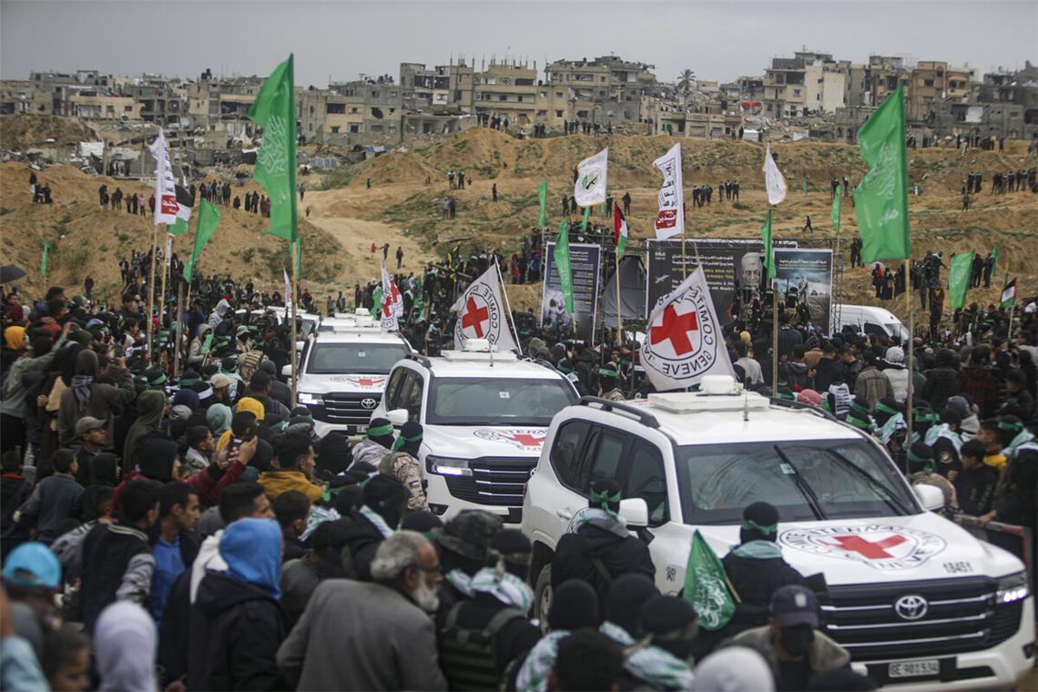 Palästinenser umringen Fahrzeuge des Roten Kreuzes nach der Annahme von vier israelischen Geiseln aus den Händen der Terrororganisation Hamas.