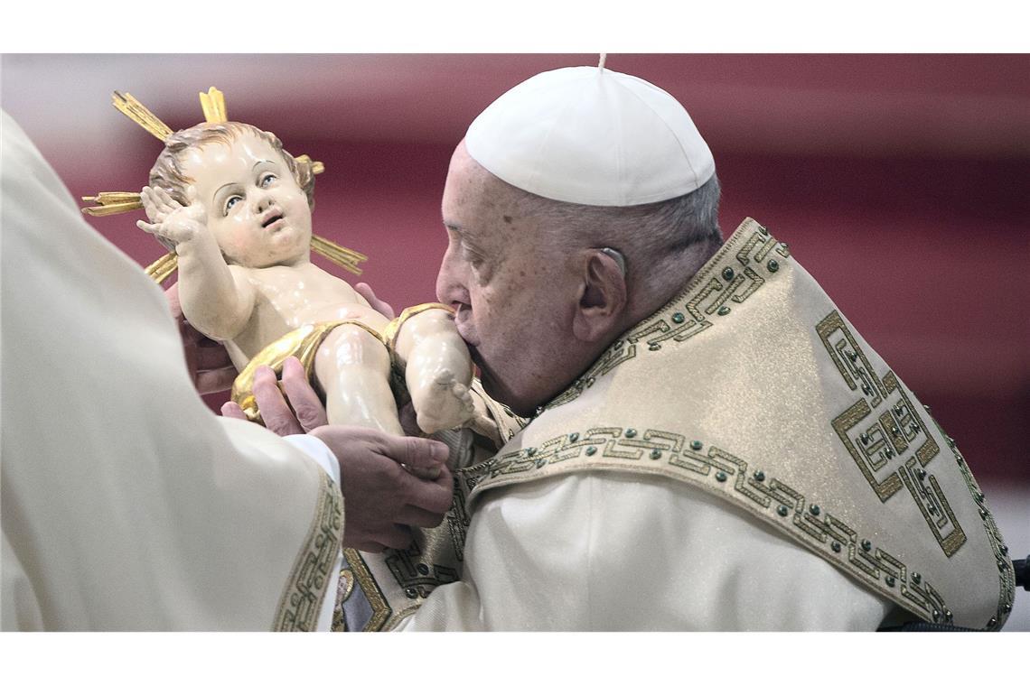 Papst Franziskus küsst die Figur eines Säuglings, der den Neugeborenen Jesus Christus darstellen soll.