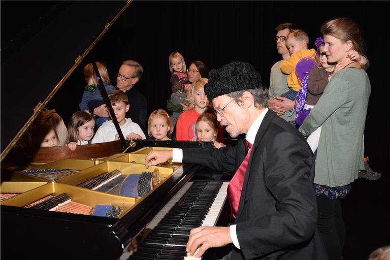 Patrick Siben (vorne) unterhält die kleinen und großen Gäste nicht nur mit Musik, sondern vermittelt auch viel Wissen, etwa über das Innenlebens eines Flügels. Foto: Elisabeth Klaper