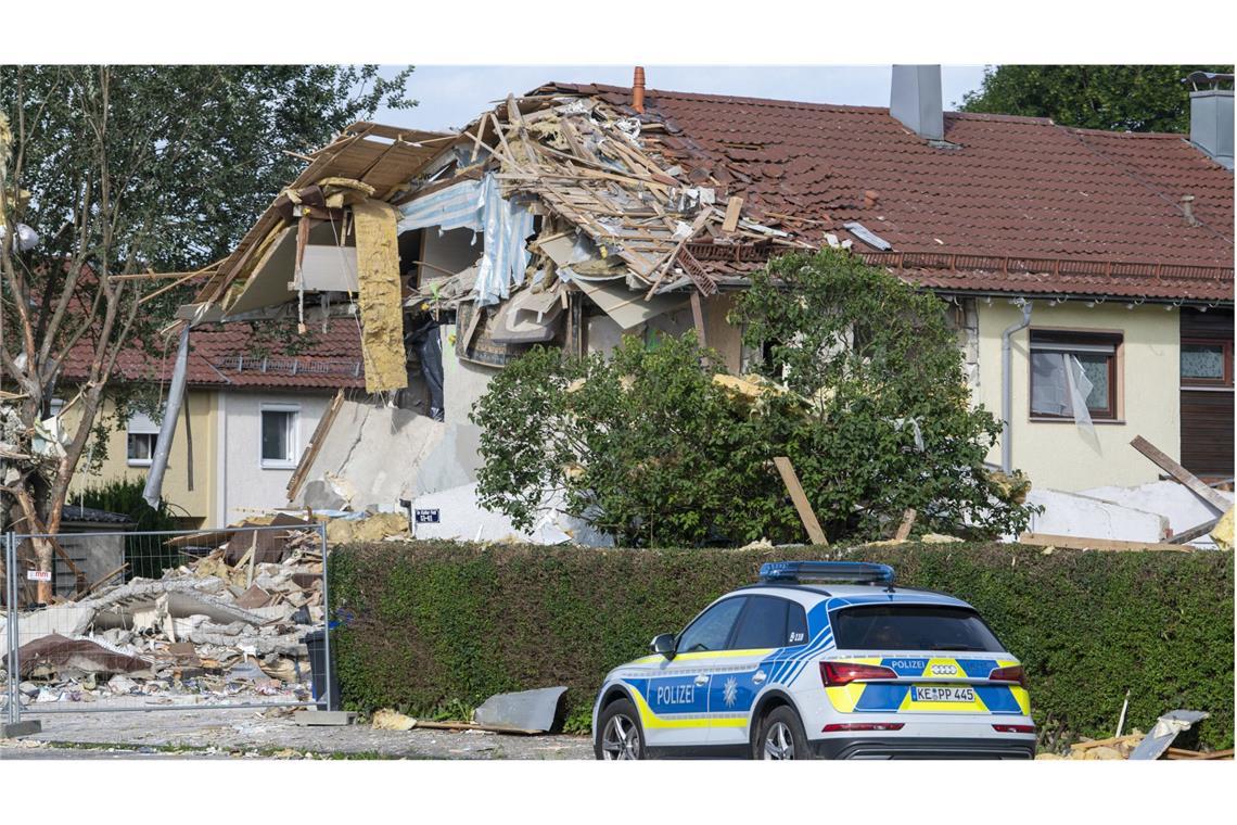 Polizei steht vor den Trümmern eines Hauses.