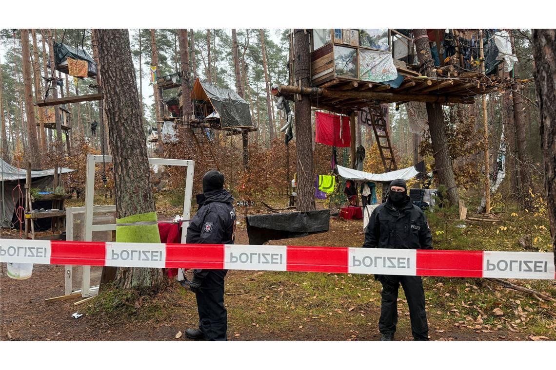 Polizeikräfte sichern das Waldgebiet hinter einer Absperrung. Umweltaktivisten, die gegen Tesla protestieren, müssen ihr Camp räumen.