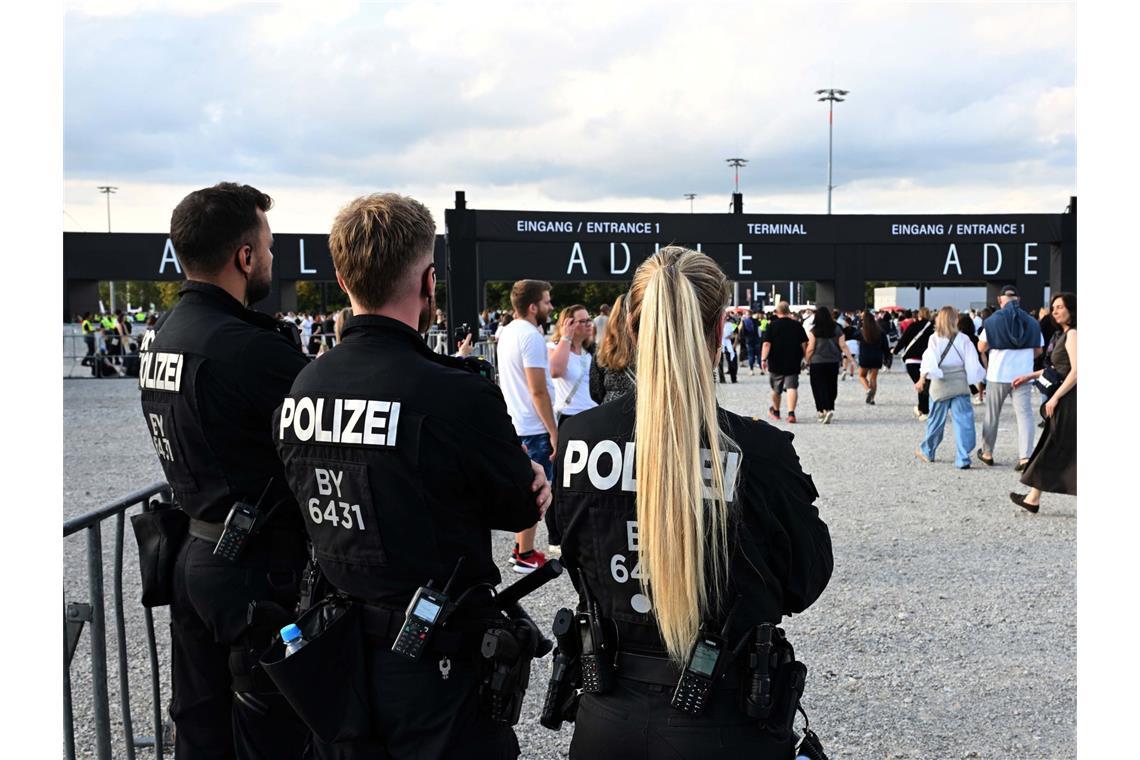 Polizisten beobachten Besucher, die auf das Konzert der britischen Sängerin Adele gehen.