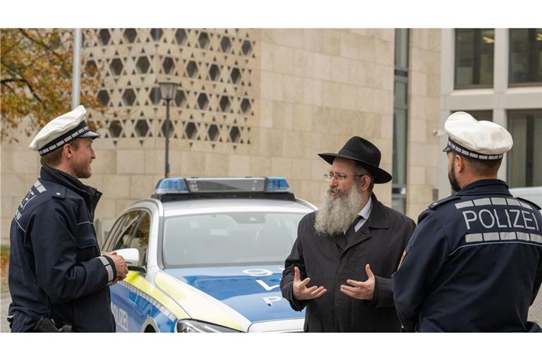 Rabbiner Shneur Trebnik und Polizisten unterhalten sich vor der Synagoge in Ulm: Juden werden immer wieder als Hauptverantwortliche für globale Krisen dargestellt.