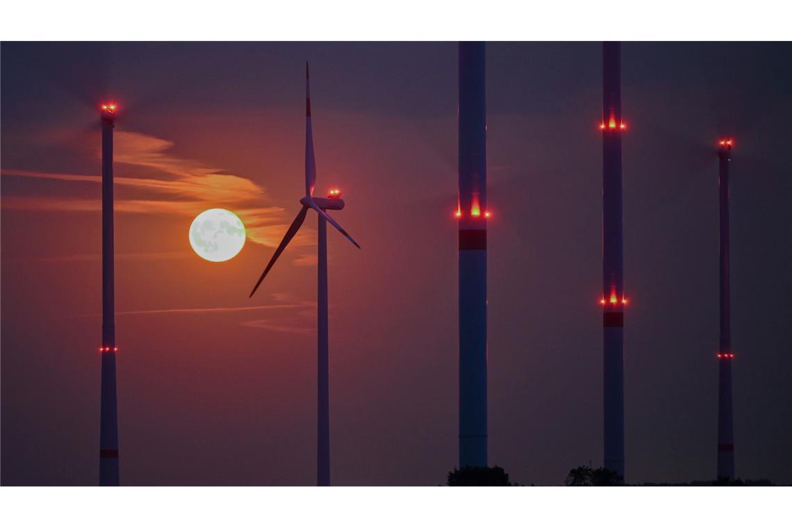 Rot leuchtet der Vollmond über Brandenburger WIndenergieanlagen.