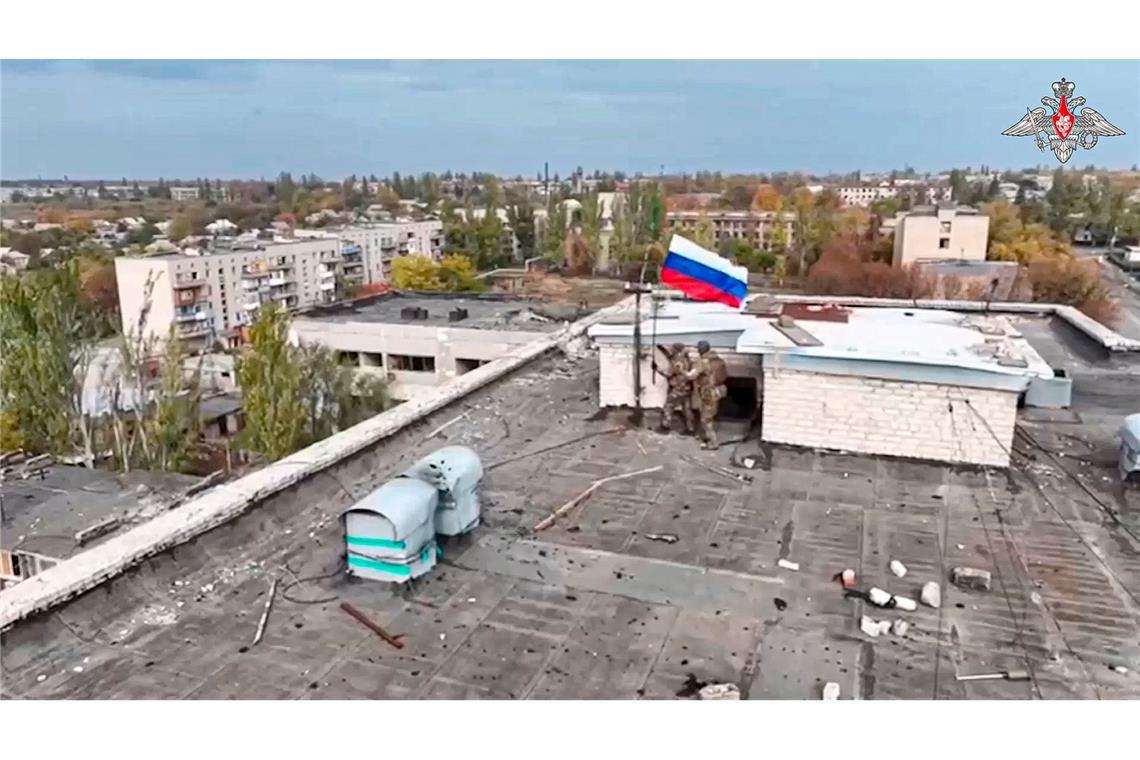 Russische Soldaten hissen in einer Ortschaft auf einem Gebäude eine Fahne nach dessen Einnahme. (Archivbild/Handout)