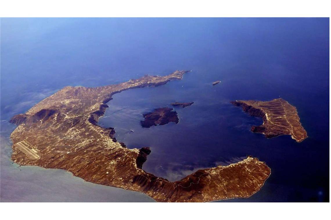 Santorini, die griechische Vulkaninsel in der Ägäis, aus der Vogelperspektive: links die Hauptinsel Thira, Nea Kameni in der Mitte der Caldera und rechts Thirasia, die den nordwestlichen Rand des Beckens bildet.