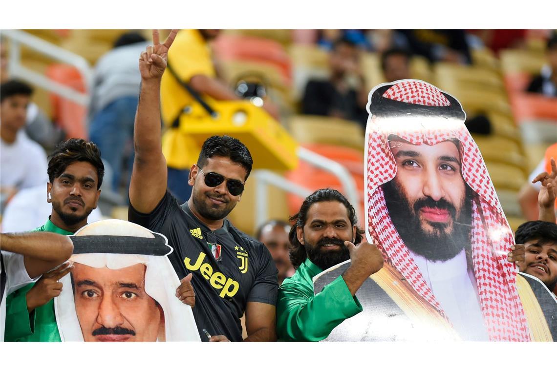 Saudische Fußballfans finden die Sport-Strategie des Königreichs um Kronprinz Mohammed bin Salman (auf dem rechten Plakat) gut.