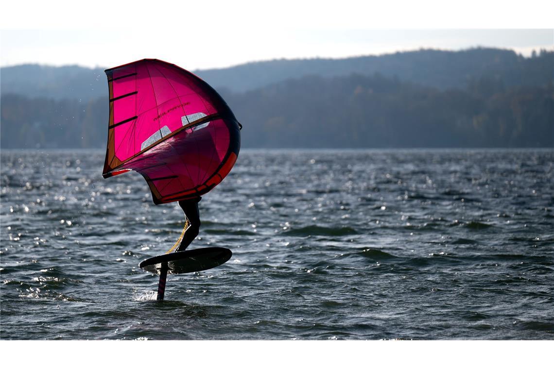 Schnell wie der Wind: Ein Mann fährt mit einem Wingfoil über den Starnberger See.