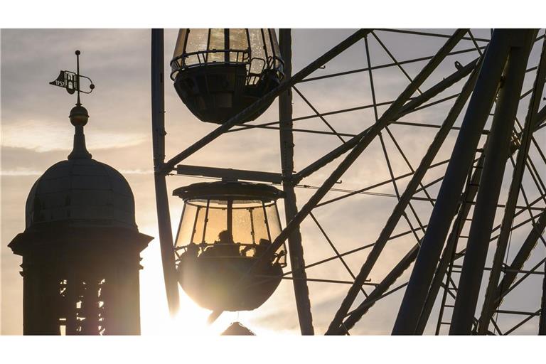 Sonnenuntergang hinter dem Riesenrad auf Weihnachtsmarkt in Magdeburg.