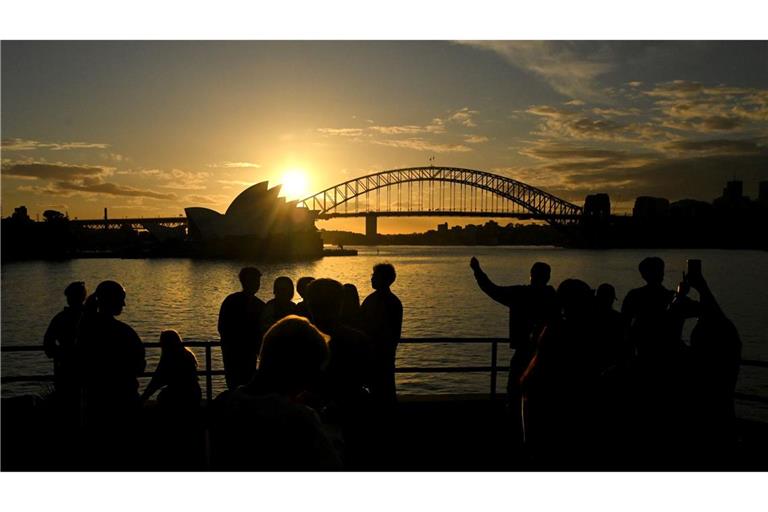 Sunset Down Under - die Sonne Australiens geht hinter dem Sydney Opera House und der Sydney Harbour Bridge spektakulär unter.