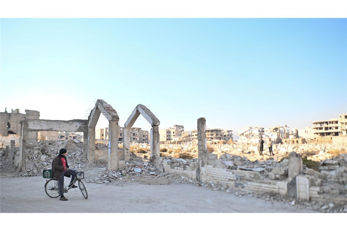 Syrien:  Ein Mann steht in Damaskus vor Ruinen des Friedhofs.