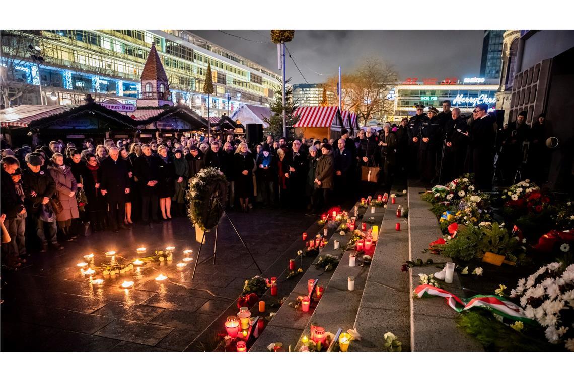 Teilnehmer des Gedenkens zum 8. Jahrestag des Terroranschlags auf den Weihnachtsmarkt am Berliner Breitscheidplatz versammeln sich am Mahnmal "Goldener Riss".