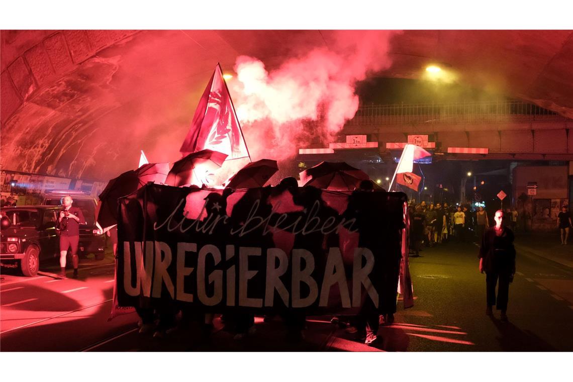 Teilnehmer einer linken Demonstration gehen durch den Stadtteil Neustadt in Dresden und zünden Pyrotechnik.