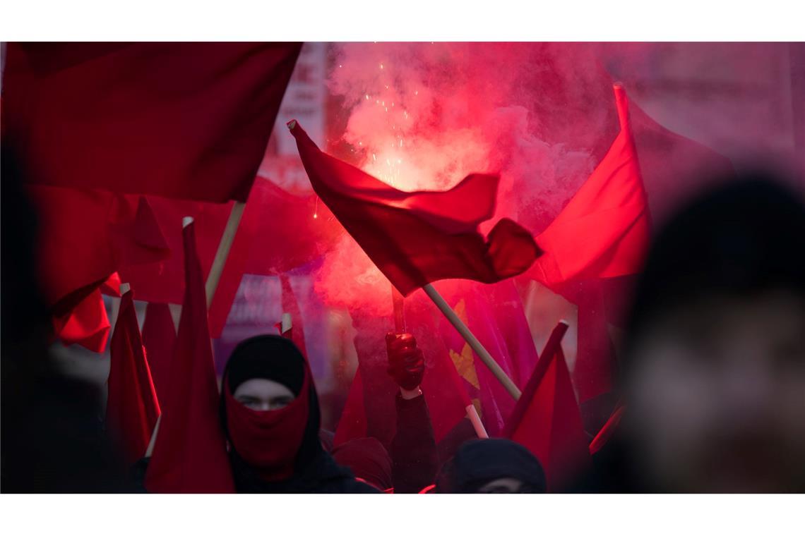 Teilnehmer zünden während der Demonstration "Luxemburg-Liebknecht-Ehrung 2025" im Gedenken an die 1919 ermordeten Rosa Luxemburg und Karl Liebknecht ein Bengalo.