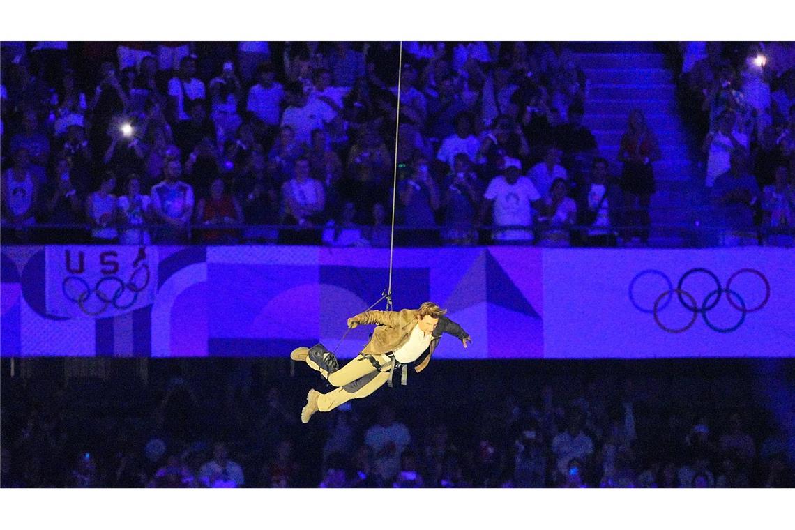 Tom Cruise fliegt bei der Abschlussfeier der Olympischen Spiele an einem Seil ins Stadion.